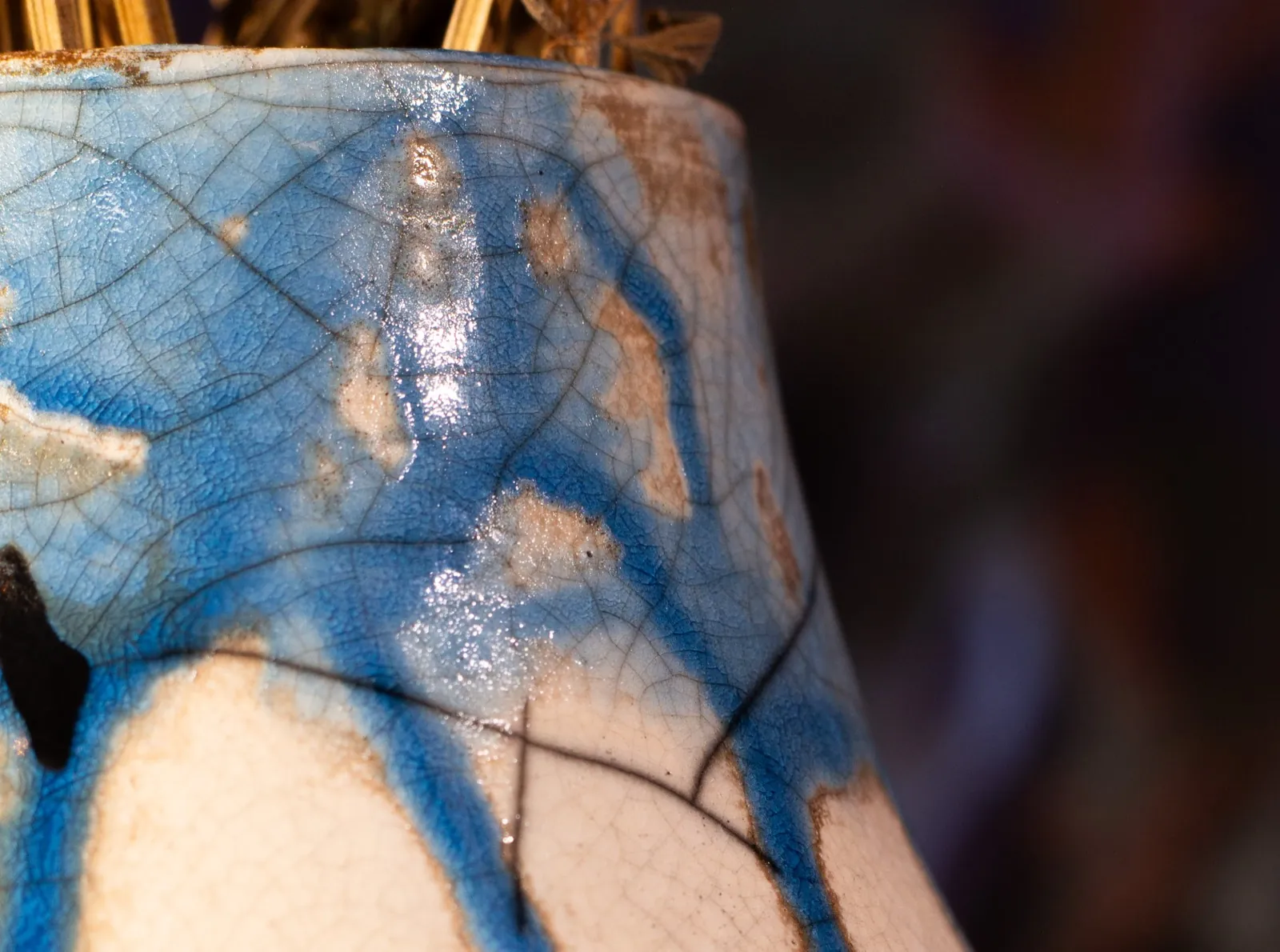 Close view of the vase's neck, where cobalt pools in the crackle and the glaze catches the light.